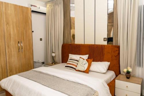 um quarto com uma cama com lençóis e travesseiros brancos em Wrightfield em Lagos