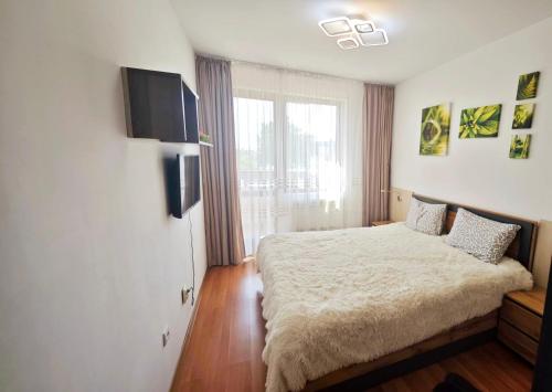 a bedroom with a bed and a flat screen tv at VIP Apartment Belvedere Club in Bansko