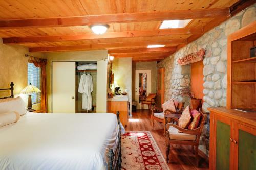a bedroom with a bed and a stone wall at The Emerald Iguana Inn in Ojai