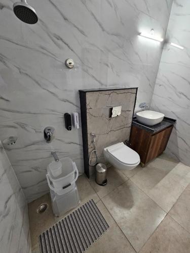 a bathroom with a toilet and a sink at Five Elements Hotels Corbett Crown Resort Jim Corbett in Rāmnagar