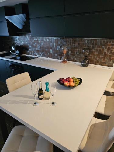 a table with two wine glasses and a bowl of fruit at Blu Petrolio Stay-Karabas Apartments in Vicenza