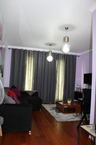 a living room with a black couch and curtains at Uptown Madalenas in Funchal