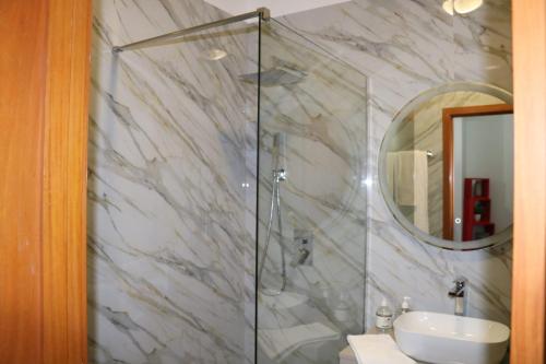 a bathroom with a shower and a sink and a mirror at Uptown Madalenas in Funchal