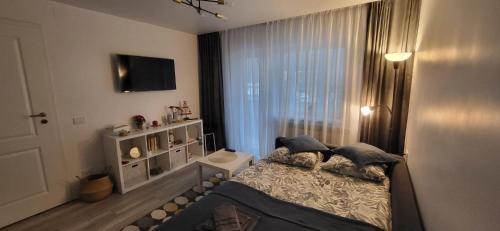 a small bedroom with a bed and a window at Spania Studio in Craiova