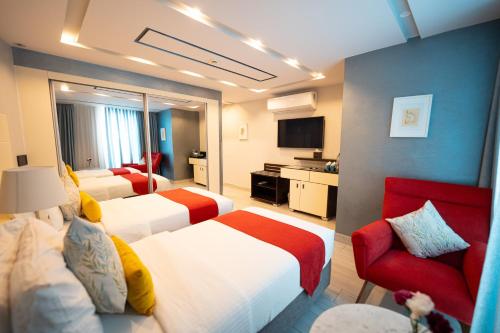 a hotel room with two beds and a red chair at Petra Boutique Hotel in Wadi Musa