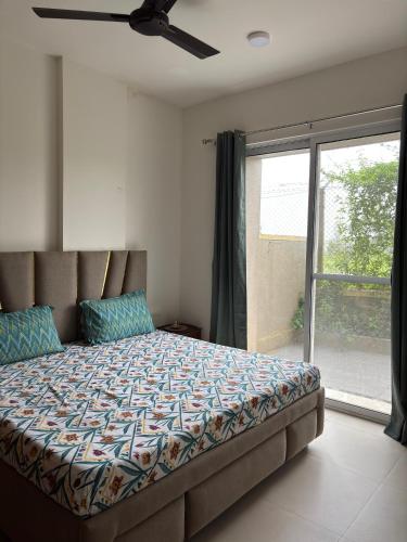 a bedroom with a bed and a large window at Staymisty igatpuri in Igatpuri