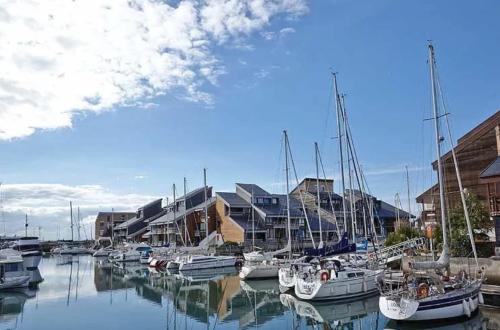 a group of boats docked in a harbor with buildings at Cosy Deauville Studio in Deauville
