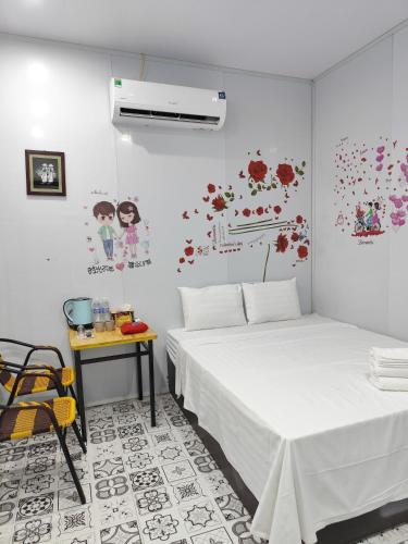 a bedroom with two beds and a table and flowers on the wall at Heartfelt Hideaway 2 in Ninh Binh