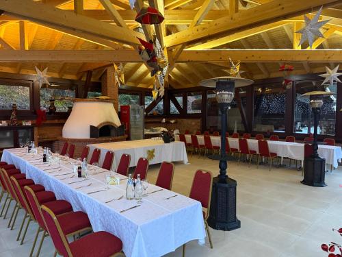 红湖Lacu Roșu Mountain Lodge的用餐室配有白色的桌子和红色的椅子