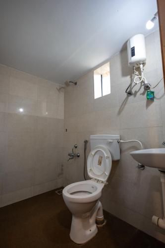 a bathroom with a toilet and a sink at Nature Bloom Resort in Paror
