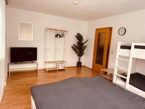 Una sala de estar con televisión y un dormitorio con literas. en FeWo Haus 9, en Lahr