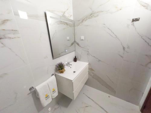 a white bathroom with a sink and a mirror at Dunas Sea and Sun Alvor in Alvor