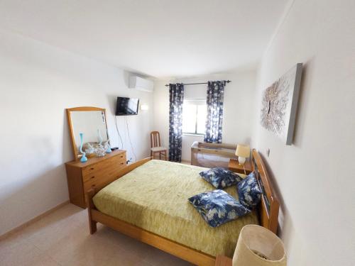 a bedroom with a bed and a dresser and a mirror at Dunas Sea and Sun Alvor in Alvor