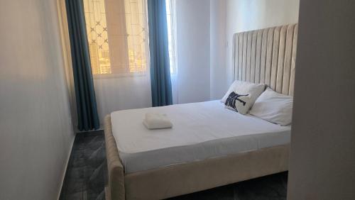 Una cama en una habitación pequeña con ventana. en EL Nido, en Mombasa