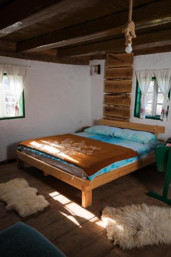 a bedroom with a large bed in a room with windows at Vikend kuce i odmaraliste JuliE etno - Sarajevo Jahorina in Tvrdimići
