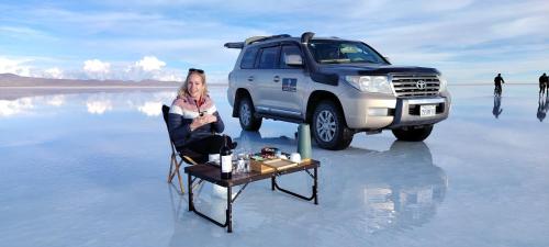 a woman sitting in a chair in front of a truck at Camper Elegance Uyuni in Carpas