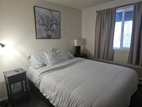 a bedroom with a bed and a deer picture on the wall at Newly Remodeled 3 Bedroom - Bright & Centrally Located Stay in Fairbanks