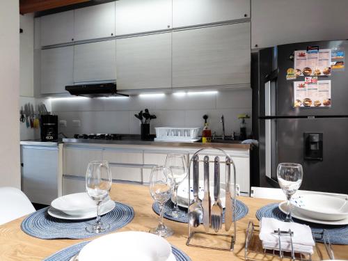 eine Küche mit einem Tisch mit Tellern und Weingläsern in der Unterkunft Cottage on the Lake - Cabaña privada - Guatapé - Jacuzzi in Guatapé