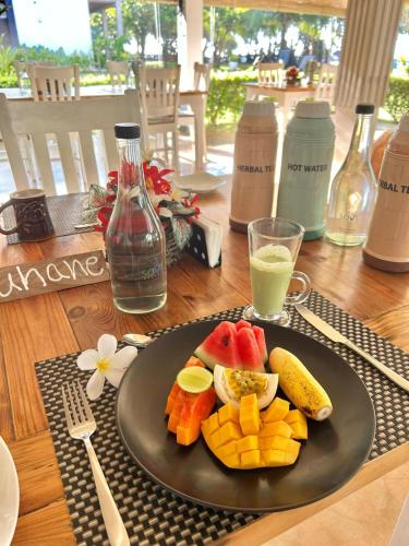 une assiette de fruits sur une table avec un verre de jus dans l'établissement Soul Wellness and Ayurveda Resort-All Meals and Treatments Included, à Dikwella