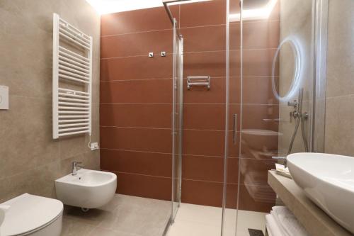 a bathroom with a shower and a toilet and a sink at Casetta Miranda in Naples