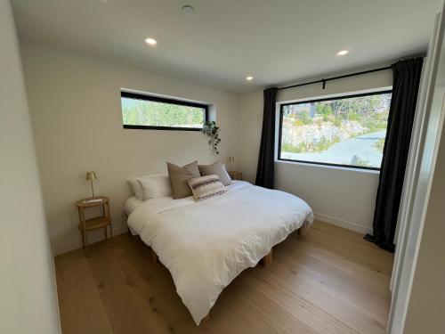 een slaapkamer met een wit bed en een groot raam bij 2BR, Views, Spacious, Luxury, New Home in Whistler
