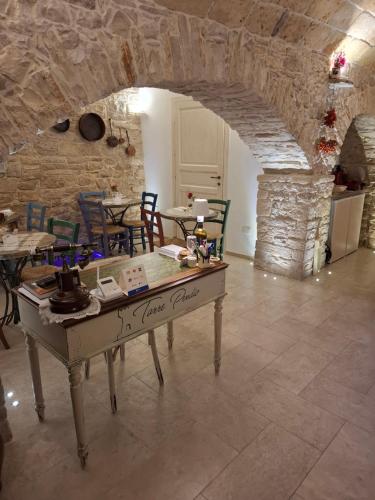 una mesa en una habitación con una pared de piedra en Torre Pendio b&b, en Corato