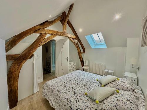 une chambre avec un grand lit et un puits de lumière dans l'établissement Maison de vacances Le Raboliot proche de Chambord, à Montlivault