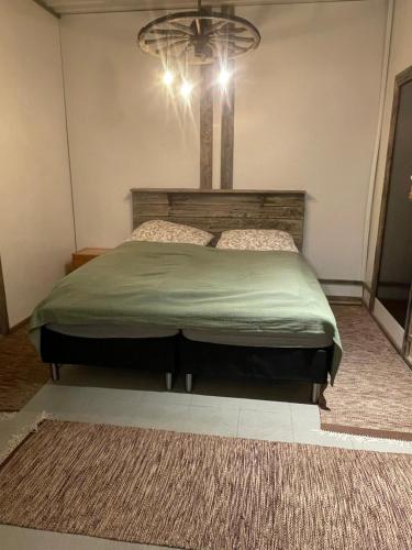 ein Schlafzimmer mit einem großen Bett und einem Kronleuchter in der Unterkunft Hopeaniitty in Huittinen