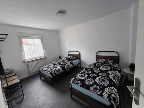 een slaapkamer met twee bedden en een raam bij Mego Unterkünfte 3 in Bönen
