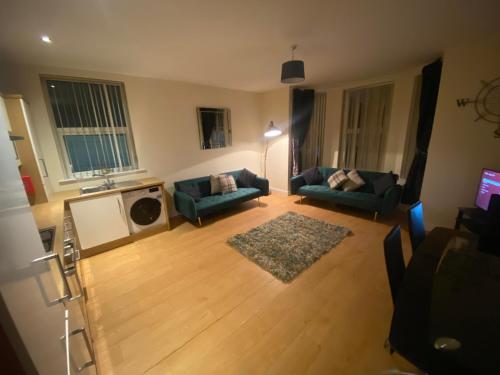 ein Wohnzimmer mit zwei Sofas und einem Fernseher in der Unterkunft vancouver place 10 min from city center and close to all shops in Belfast