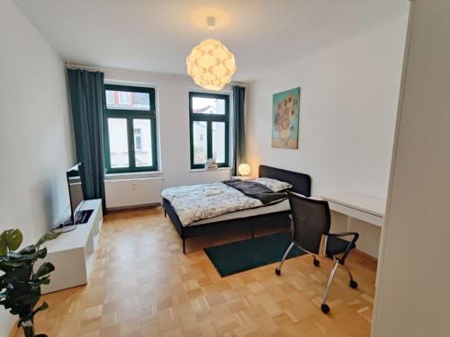 a bedroom with a bed and a table and chairs at Lebensfreude in Markkleeberg