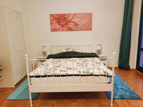 a white bed in a room with a painting at Lebensfreude in Markkleeberg