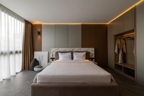 een slaapkamer met een groot bed met witte lakens bij Awwa Boutique Hotel in Canggu