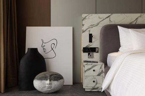 een slaapkamer met een bed en een foto van een vrouw bij Awwa Boutique Hotel in Canggu