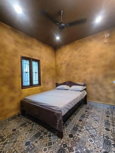 una camera da letto con un letto e un ventilatore a soffitto di Sp Queens Garden a Madurai