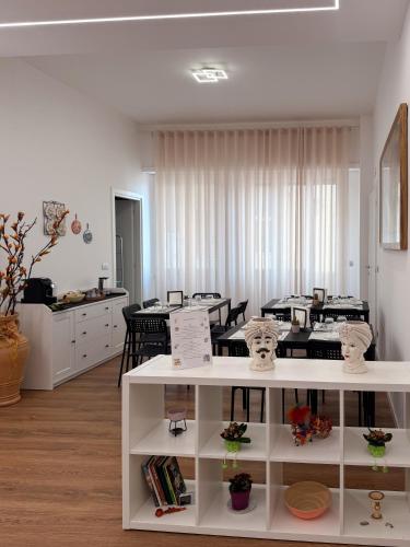 a living room with tables and chairs in a room at B&B Ovidio in Catania