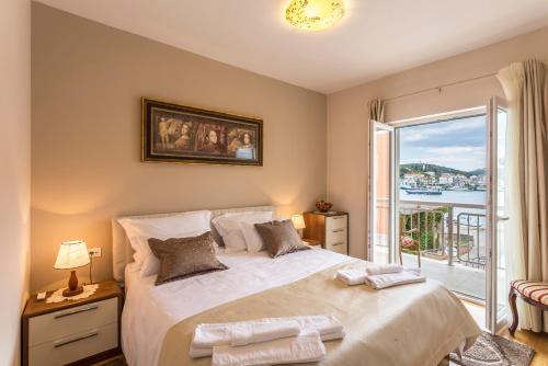 a bedroom with a large bed with a balcony at Flores Luxury Suites-Rogoznica in Rogoznica