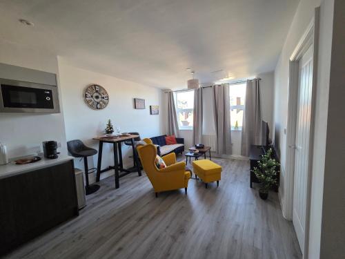 a living room with a yellow chair and a table at Solihull 10 mins to NEC and Airport Free Parking in Solihull