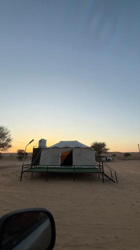 a tent sitting in the sand in the desert at Hawyan Camp in Badīyah