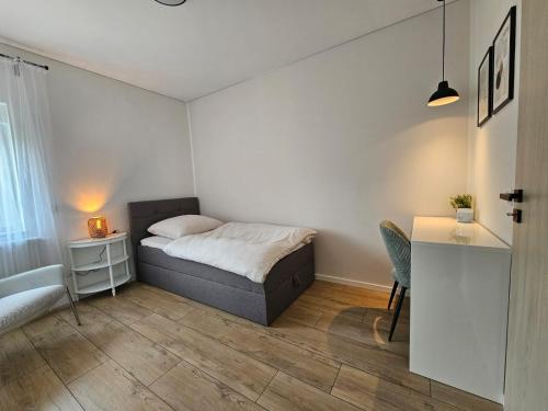 una piccola camera da letto con un letto e una scrivania di Exklusive Wohnung im Herzen Ramsteins a Ramstein-Miesenbach