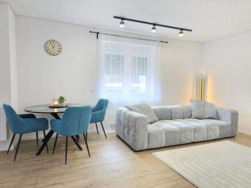 un soggiorno con un divano, un tavolo e delle sedie di Exklusive Wohnung im Herzen Ramsteins a Ramstein-Miesenbach