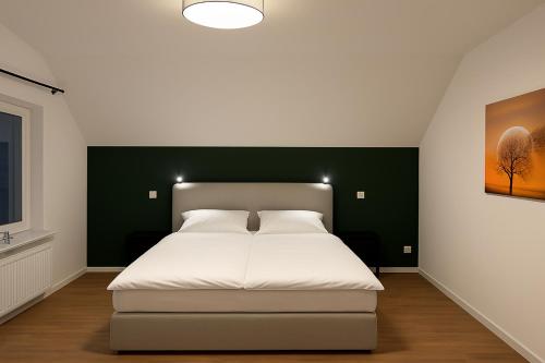 una camera con un letto bianco e una parete verde di Ferienwohnung Gut Lehmhof a Lehmrade