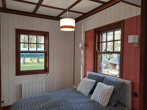 une chambre avec un lit et deux fenêtres dans l'établissement Le rêve au fil de l'eau, à Marmagne