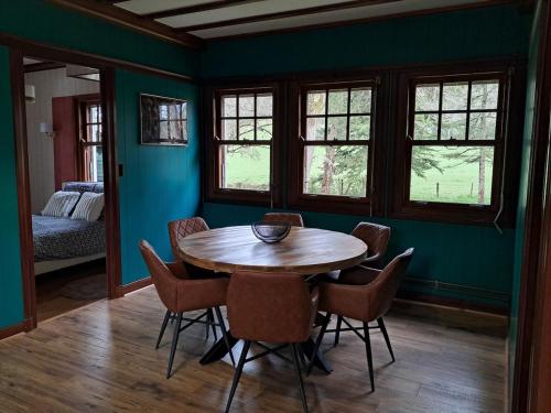 une salle à manger avec une table et des chaises en bois dans l'établissement Le rêve au fil de l'eau, à Marmagne