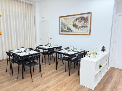 ein Esszimmer mit schwarzen Tischen und schwarzen Stühlen in der Unterkunft B&B Ovidio in Catania