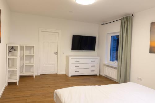 una camera da letto con un letto e una TV a parete di Ferienwohnung Gut Lehmhof a Lehmrade
