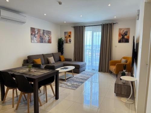 a living room with a couch and a table at East Legon Loxwood House Condo with Gym & Pool in Accra