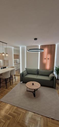 a living room with a green couch and a table at Apartman La Campanella 2 in Vrnjci