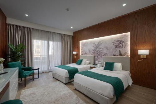 two beds in a hotel room with green sheets at Tolip Family Park Hotel in Cairo