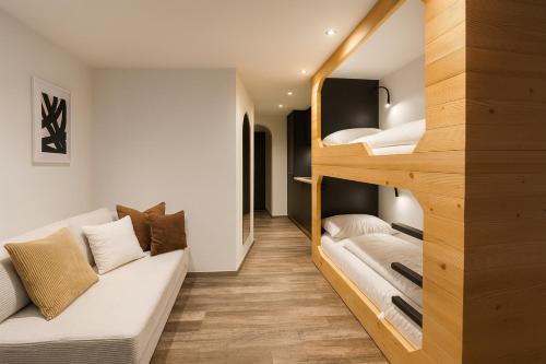 a room with two bunk beds and a couch at TinyAlps in Saalbach-Hinterglemm